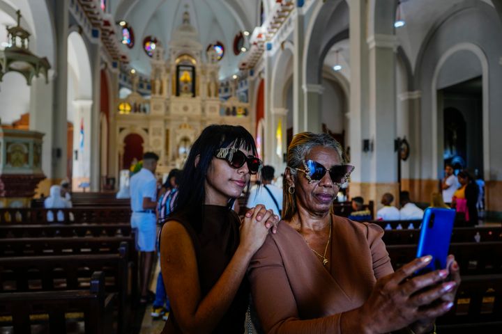 Οι άνθρωποι βγάζουν φωτογραφίες μέσα στο ιερό της Παναγίας της Φιλανθρωπίας του El Cobre στο El Cobre, Κούβα, Κυριακή, 11 Φεβρουαρίου 2024. Η αναγνωρισμένη από το Βατικανό Παναγία, που λατρεύεται από τους Καθολικούς και τους οπαδούς των αφρο-κουβανικών παραδόσεων της Σαντερίας, βρίσκεται στην καρδιά της κουβανικής ταυτότητας, ενώνοντας συμπατριώτες από το κομμουνιστικό νησί της Καραϊβικής με εκείνους που εξορίστηκαν ή μετανάστευσαν στις Η.Π.Α. (AP Photo/Ramon Espinosa)