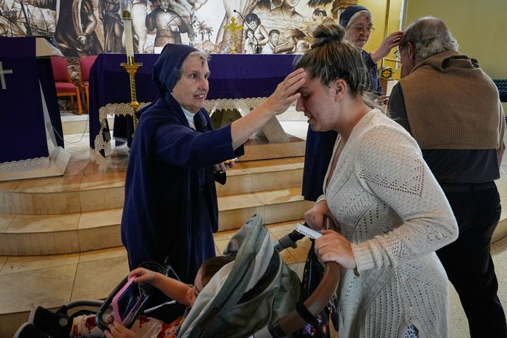 Η αδελφή Eva Perez σηματοδοτεί το μέτωπο της Nathalye Parajes με ένα σταυρό από τέφρα κατά τη διάρκεια της Λειτουργίας της Τετάρτης της Τέφρας στο ιερό Virgin of Charity, γνωστό ως La Ermita, στο Μαϊάμι της Φλόριντα, Τετάρτη, 14 Φεβρουαρίου 2024. Η αναγνωρισμένη από το Βατικανό Παναγία, σεβαστή από Καθολικοί και οπαδοί των αφρο-κουβανικών παραδόσεων της Σαντερίας, βρίσκεται στο επίκεντρο της κουβανικής ταυτότητας, ενώνοντας συμπατριώτες από το κομμουνιστικό νησί της Καραϊβικής μέχρι εκείνους που εξορίστηκαν ή μετανάστευσαν στις Η.Π.Α. (AP Photo/Marta Lavandier)