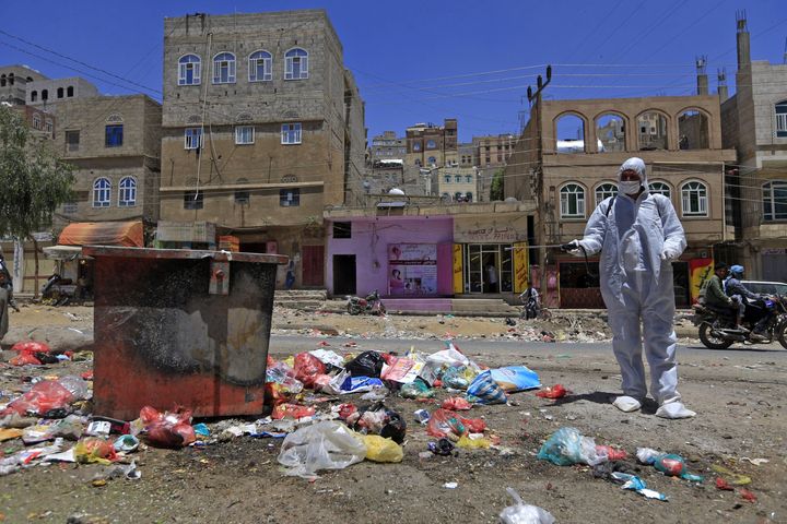 A Yemeni volunteer sprays disinfectant over garbage in the one of Sanaa's impoverished neighbourhoods, on March 30, 2020, amid concerns of a coronavirus outbreak. Yemen is one of 10 countries still reeling from the impacts of the pandemic, according to U.N.'s report.