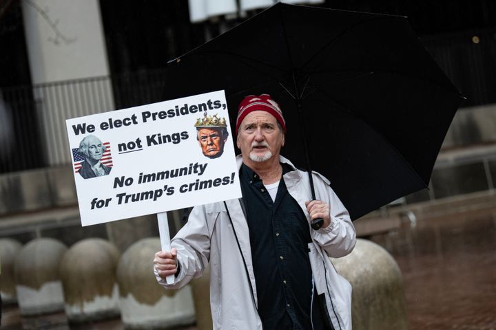 A man protests before Trump's motorcade departs the E. Barrett Prettyman U.S. Courthouse on January 9, 2024, in Washington, D.C.