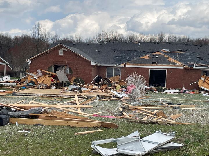 Debris covers the ground in front of a damaged home after severe weather passed the area on March 14, 2024, in Jefferson Manor Subdivision near Hanover, Ind. 