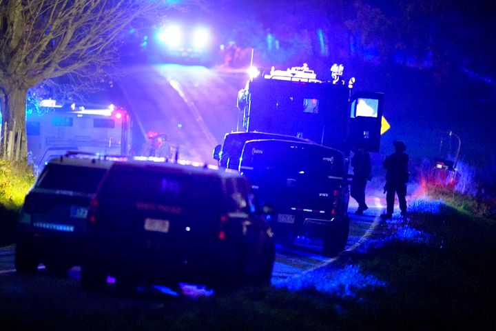 Law enforcement officers, right, stand near armored and tactical vehicles, center, near a property on Meadow Road, in Bowdoin, Maine, following a mass shooting, Thursday, Oct. 26, 2023. An independent commission investigating the deadliest shooting in Maine, that left 18 dead, released their interim report on Friday, March 15, 2024. (AP Photo/Steven Senne, File)