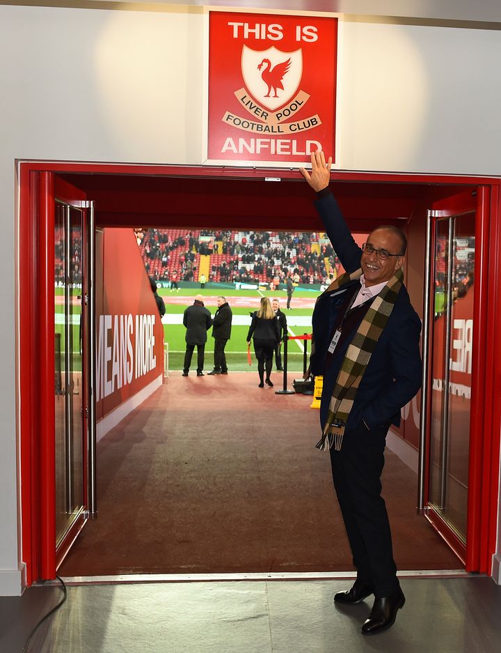 Theo Paphitis posing for a photograph in-front of the "This is Anfield" sign at Liverpool's Anfield stadium.