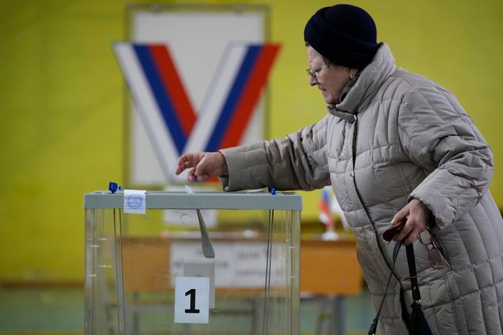 A woman casts a ballot at a polling station located in the school gymnasium during a presidential election in St. Petersburg, Russia, on March 15, 2024.