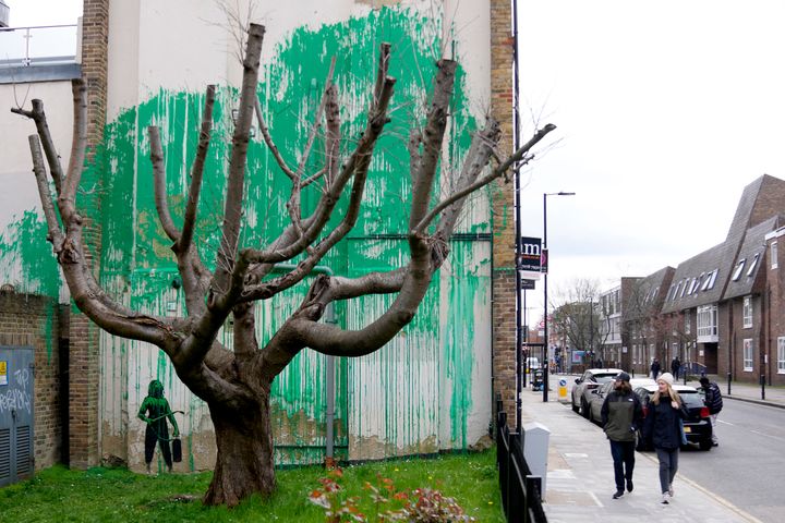ロンドンの壁に描かれた新しいバンクシーの絵を見る人々