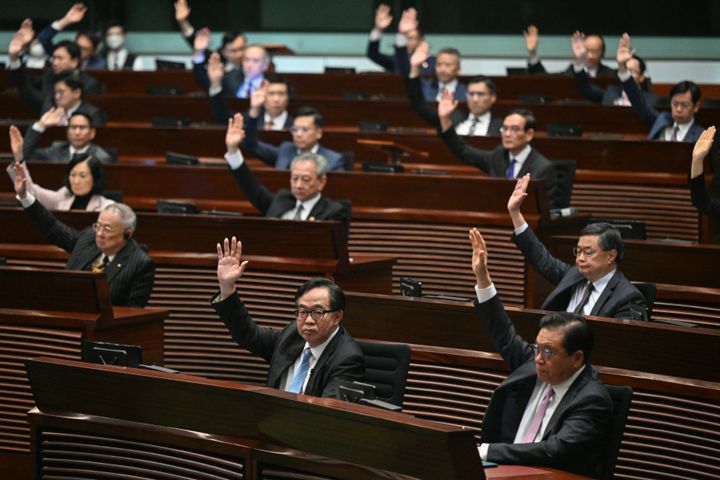 Lawmakers vote for Article 23 in the chamber of the Legislative Council after the conclusion of the readings of the Article 23 National Security Law, in Hong Kong on March 19, 2024. Hong Kong's legislature unanimously passed a new national security law on March 19, introducing penalties such as life imprisonment for crimes related to treason and insurrection, and up to 20 years' jail for the theft of state secrets. (Photo by PETER PARKS/AFP via Getty Images)