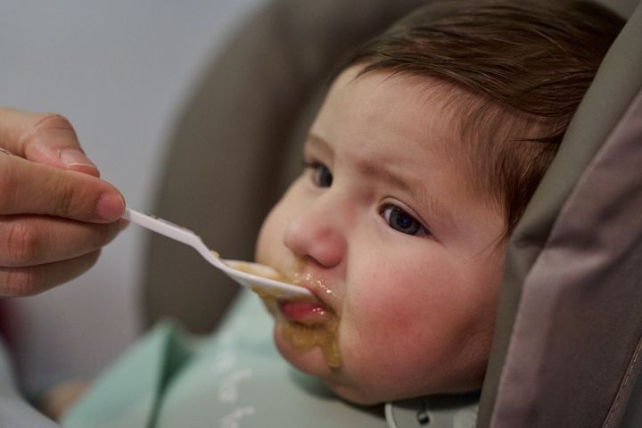 Adorable messy eater: baby's first mealtime experience with pureed food in high chair