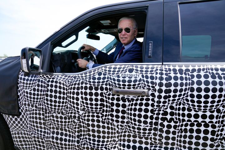 President Joe Biden stops to talk to the media as he drives a Ford F-150 Lightning truck at Ford Dearborn Development Center, May 18, 2021, in Dearborn, Mich.