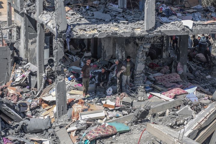 2024 年 3 月 20 日，以色列连夜轰炸加沙地带中部努塞拉特难民营的哈巴什家，巴勒斯坦人坐在被毁房屋的废墟上。（法新社照片）