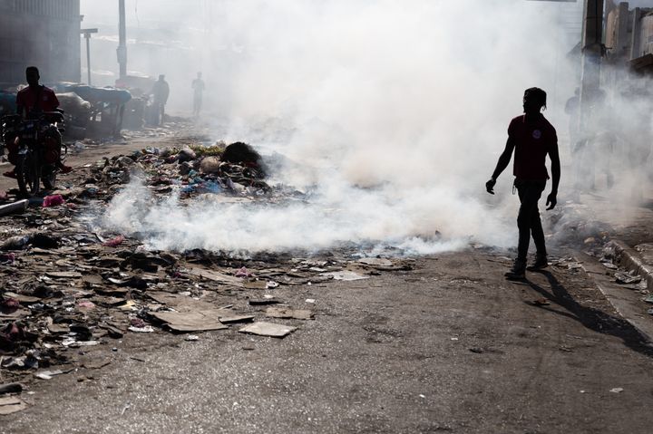 People burn garbage close to the bodies of the dead as at least 10 bodies of gang members lie in the streets following the exchange of gunfire between armed gangs in Petion-Ville on the outskirts of Port-au-Prince, Haiti on March 18, 2024. (Photo by Guerinault Louis/Anadolu via Getty Images)