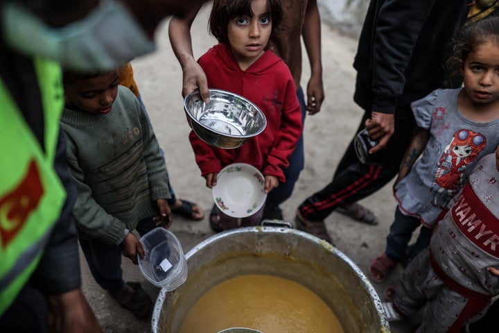 DEIR AL BALAH, GAZA - MARCH 21: Palestinian children stand in queue to receive food supplies from charity organizations in Deir al-Balah, Gaza on March 21, 2024. (Photo by Ali Jadallah/Anadolu via Getty Images)