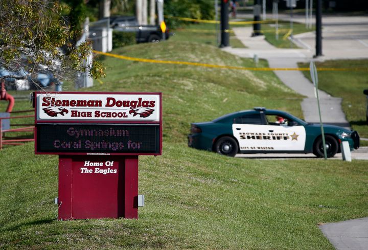 In this Feb. 15, 2018, file photo, law enforcement officers block off the entrance to Marjory Stoneman Douglas High School in Parkland, Fla., following a deadly shooting at the school. (AP Photo/Wilfredo Lee, File)