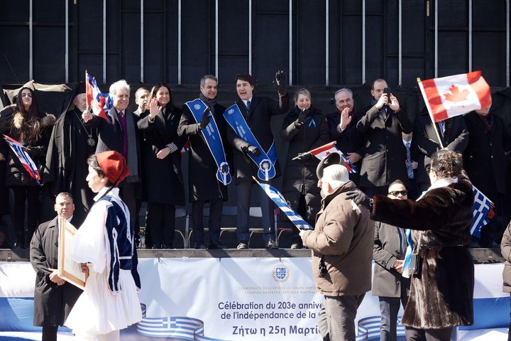 Τα μέλη της ελλληνικής αποστολής και ο Καναδός Πρωθυπουργός παρακολουθούν την παρέλαση από την εξέδρα των επισήμων