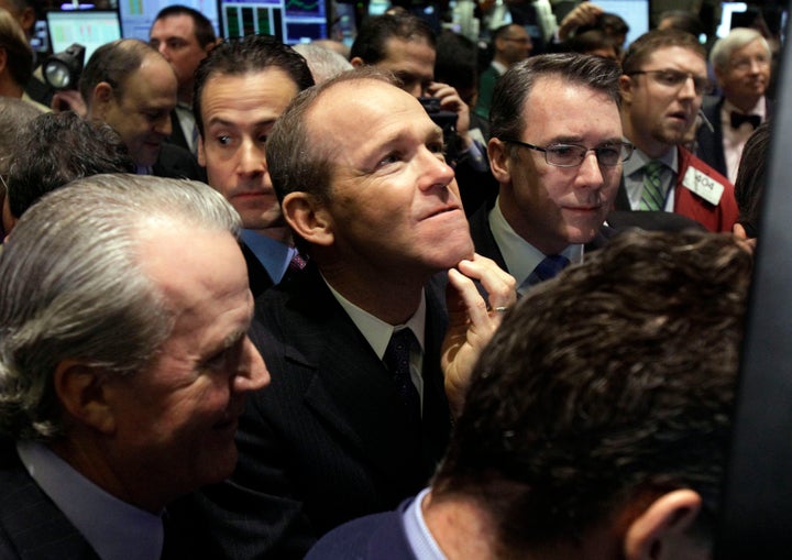 FILE - Then-Nielsen Company CEO David Calhoun, center, watches progress as he waits for the company's IPO to begin trading, Jan. 26, 2011, on the floor of the New York Stock Exchange. Calhoun will be stepping down at the end of the year from the top job at Boeing, which is under pressure from major airlines wanting to know how the company plans to fix problems in the manufacturing of its planes. (AP Photo/Richard Drew, File)