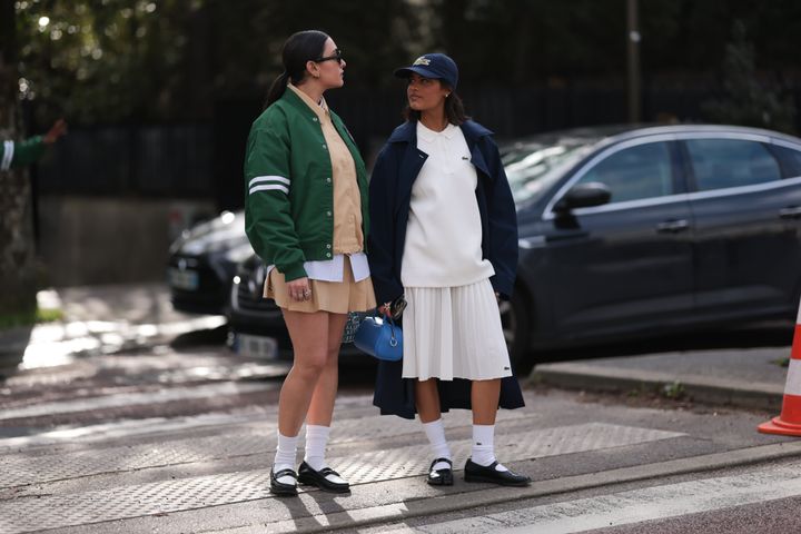 Guests seen wearing tennis-core staples outside the Lacoste show during Paris fashion week in March 2024.