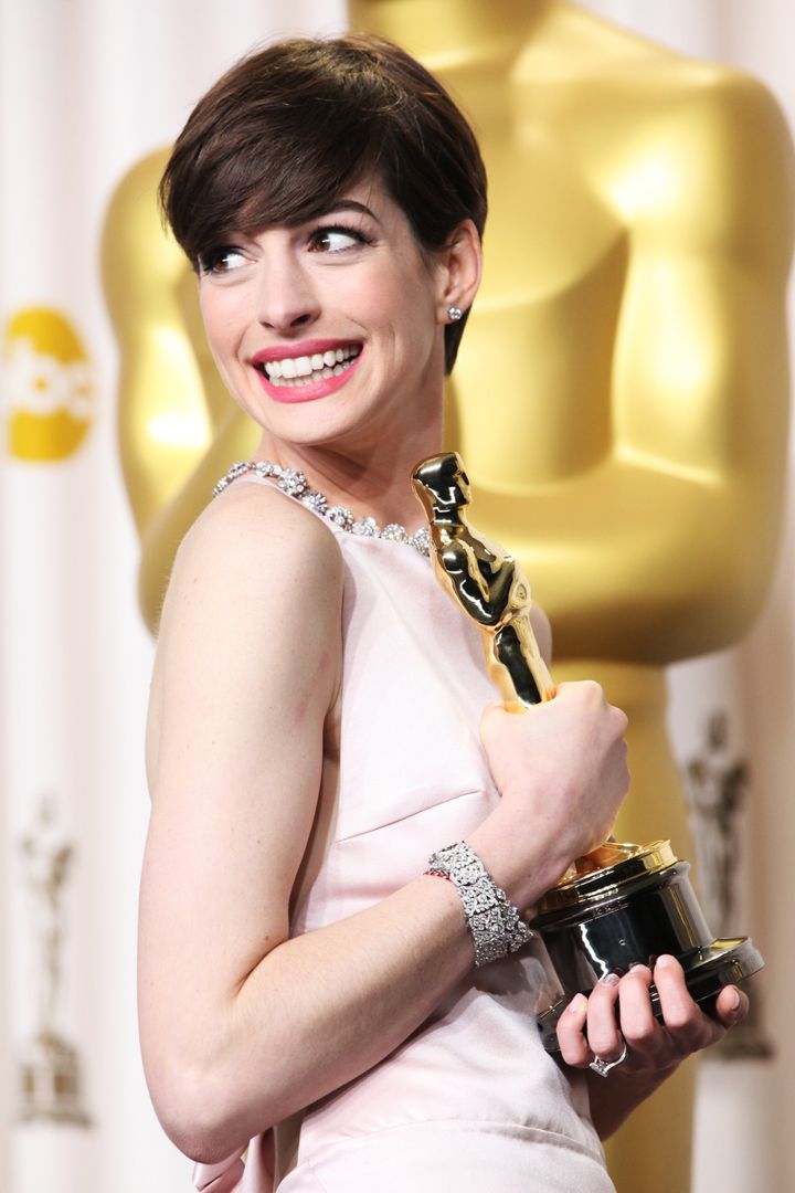 Anne Hathaway posing with her Oscar in 2013