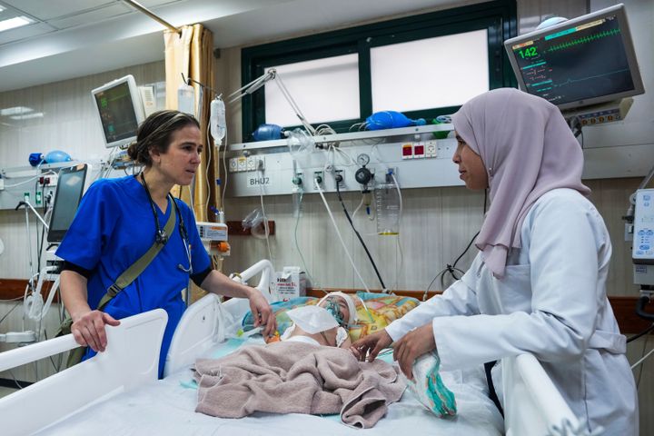Dr. Tanya Haj-Hassan (L), a pediatrician, examines wounded children at Al-Aqsa Martyrs Hospital in Deir al-Balah, central Gaza, Saturday, March 16, 2024.