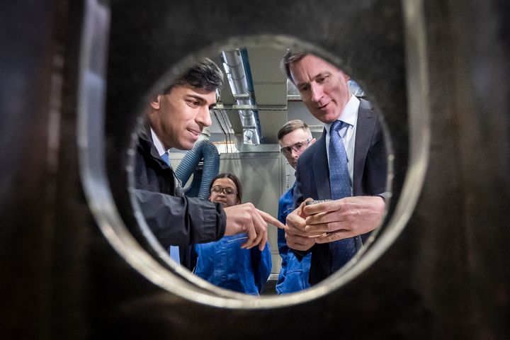Rishi Sunak and Jeremy Hunt react as they visit an engineering firm in Barrow-in-Furness, Cumbria, on March 25.