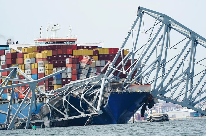 A cargo ship is stuck under the part of the structure of the Francis Scott Key Bridge after the ship hit the bridge, Tuesday March 26, 2024, in Baltimore, Va. (AP Photo/Steve Helber)