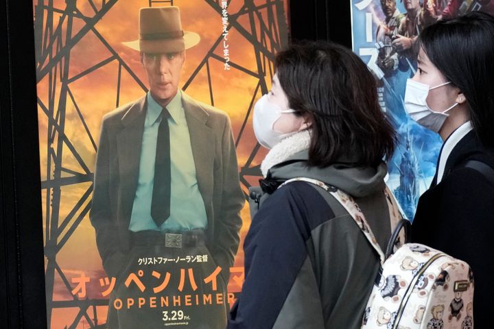 People walk by a poster to promote the movie "Oppenheimer" Friday, March 29, 2024, in Tokyo. “Oppenheimer” finally premiered Friday in the nation where two cities were obliterated 79 years ago by the nuclear weapons invented by the American scientist who was the subject of the Oscar-winning film. Japanese filmgoers' reactions understandably were mixed and highly emotional. (AP Photo/Eugene Hoshiko)