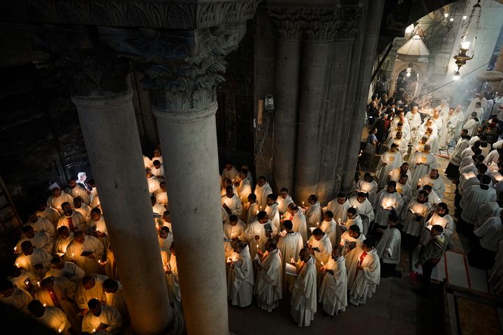 Καθολικοί κληρικοί κρατούν κεριά καθώς περπατούν κατά τη διάρκεια της πομπής του πλυσίματος των ποδιών στην εκκλησία του Παναγίου Τάφου, όπου πολλοί χριστιανοί πιστεύουν ότι ο Ιησούς σταυρώθηκε, θάφτηκε και αναστήθηκε, στην Παλιά Πόλη της Ιερουσαλήμ, Πέμπτη 28 Μαρτίου 2024