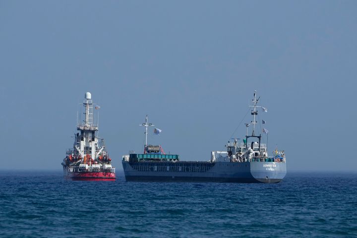 A cargo ship, right, and a ship belonging to the Open Arms aid group, are loaded with 240 tons of canned food destined for Gaza prepare to set sail outside the Cypriot port of Larnaca, Cyprus, on Saturday, March 30, 2024. (AP Photo/Petros Karadjias)