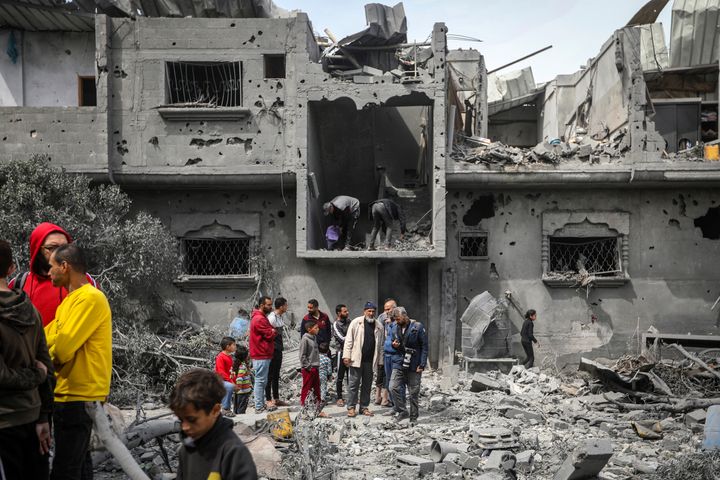 Palestinians inspect the damage to a residential building after an Israeli airstrike in the Maghazi refugee camp, central Gaza Strip, Friday, March 29, 2024. (AP Photo/Ismael Abu Dayyah)