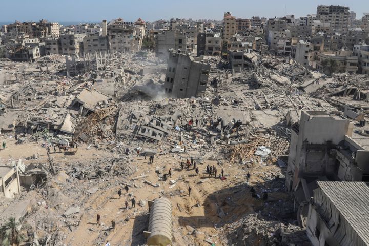 Palestinians walk through the destruction left by the Israeli air and ground offensive on the Gaza Strip near al-Shifa Hospital in Gaza City, Monday, April 1, 2024.