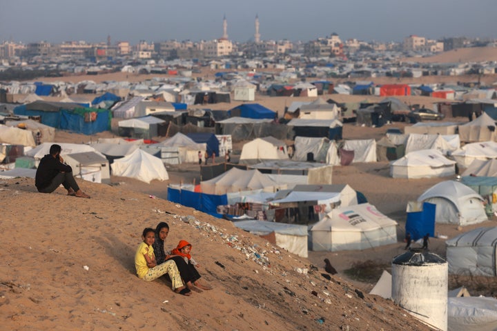 Palestinian children sit on a hill next to tents housing the displaced in the southern Gaza city of Rafah on March 30, 2024, as Israel continues its military offensive on the territory.