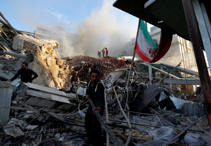 Emergency services work at a destroyed building hit by an airstrike in Damascus, Syria, Monday, April 1, 2024. An Israeli airstrike has destroyed the consular section of Iran's embassy in Damascus, killing or wounding everyone inside, Syrian state media said Monday.