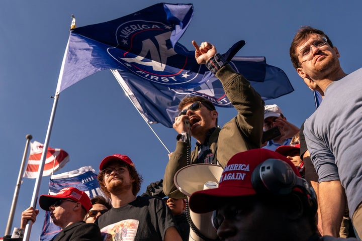 Nick Fuentes right-wing podcaster, center, speaks in front of flags that say, "America First," at a pro-Trump march, Nov. 14, 2020, in Washington. 