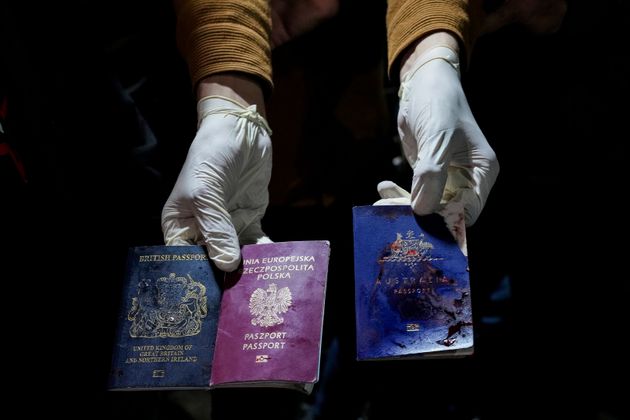 A man displays blood-stained British, Polish, and Australian passports after an Israeli airstrike, in Deir al-Balah, Gaza Strip.