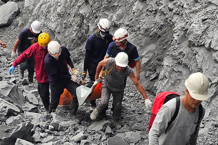 In this photo released by the Hualien Fire Department, firefighters and quarry workers evacuate a body from the Ho Ren Quarry a day after a powerful earthquake struck in Hualien County, eastern Taiwan, on April 4, 2024.