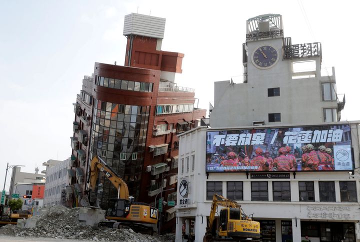 A banner reading ''Never Give Up. Hualien Come On" hangs near a partially collapsed building a day after a powerful earthquake struck, in Hualien City, eastern Taiwan, on April 4, 2024.
