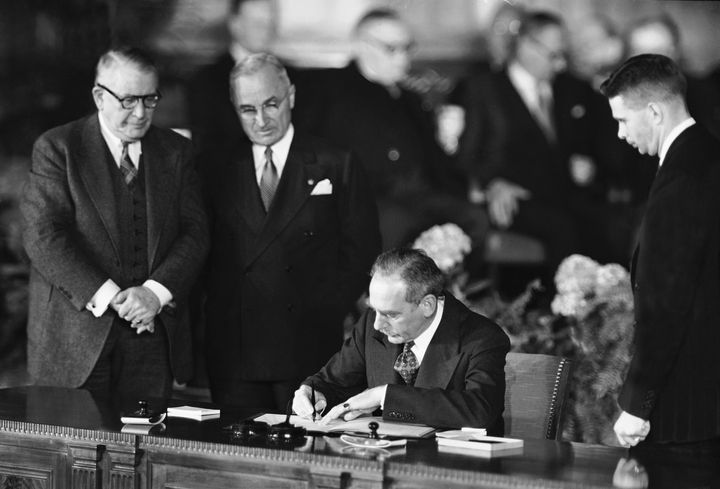 Secretary of State Dean Acheson signs the Atlantic defense treaty for the United States, April 4, 1949.