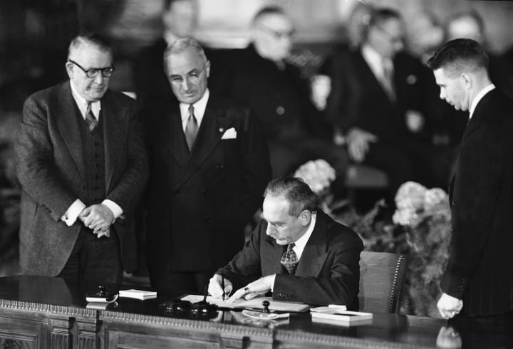 Secretary of State Dean Acheson signs the Atlantic defense treaty for the United States, April 4, 1949.