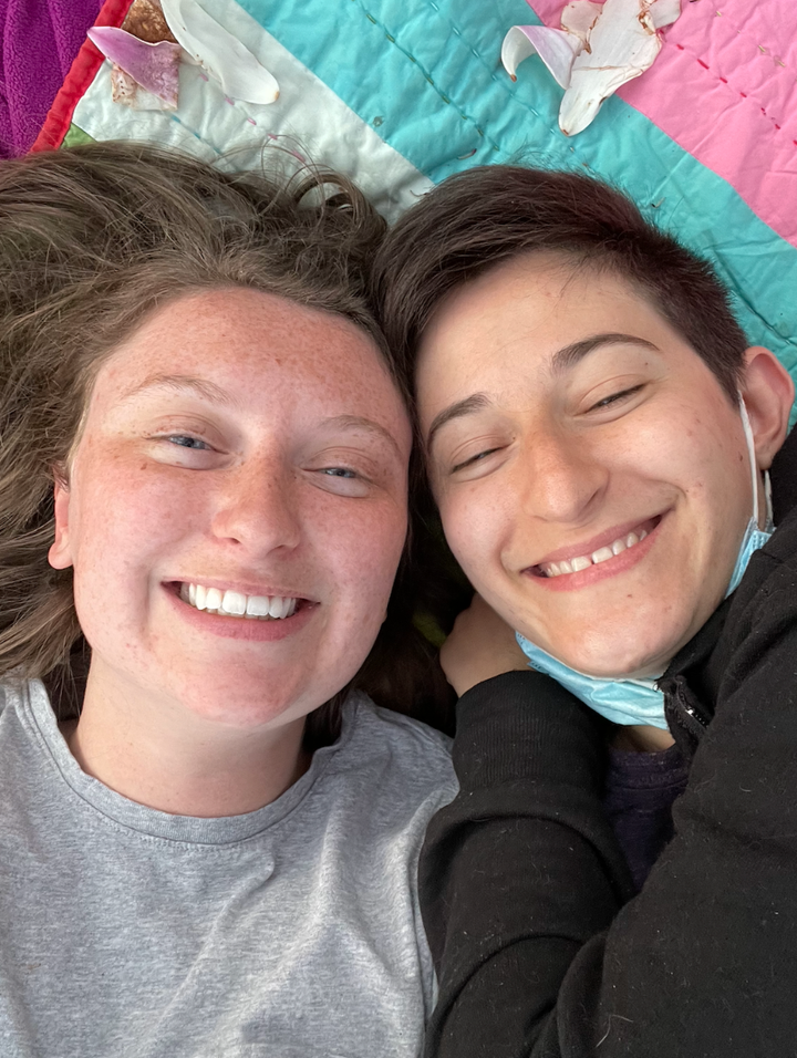 The author (left) and Quinn a few months after they began dating, laying under their favorite magnolia tree in bloom. "It's since become a yearly spring tradition," they write.