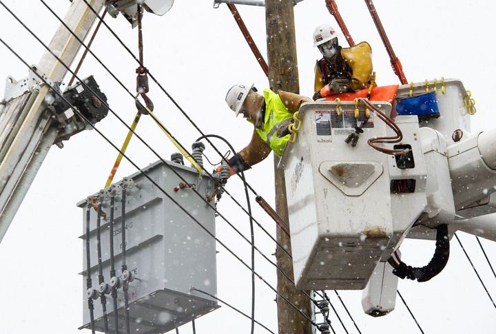As snow showers fall, linemen from Chain Electric, a contract utility crew that drove in from Mississippi to help Consolidated Edison, install a new transformer November 7, 2012, to help restore electric power that has been out since Hurricane Sandy struck the East Coast, in the community of Oakwood Beach, on Staten Island, New York.