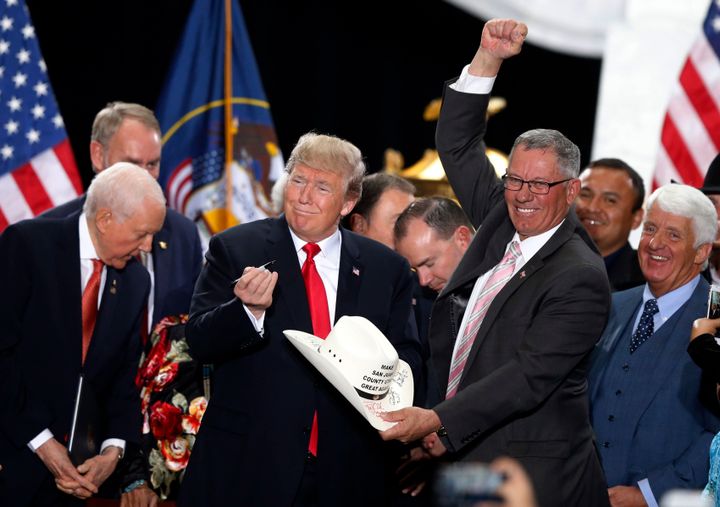 2017 年 12 月 4 日，唐纳德·特朗普总统在盐城犹他州议会大厦签署缩小熊耳和埃斯卡兰特大楼梯国家纪念碑规模的公告后，在圣胡安县委员会主席布鲁斯·亚当斯的帽子上签名湖城。 此后，乔·拜登总统恢复了纪念碑的边界。