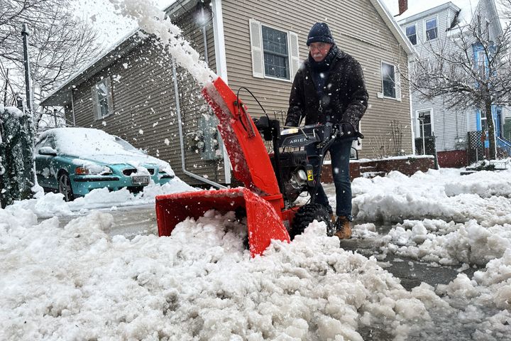 Phil Cloutier removes heavy, wet snow after an early-spring Nor'easter on April 4, 2024, in Portland, Maine.