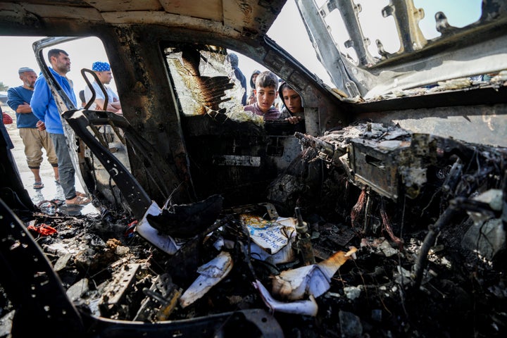 People inspect the site where World Central Kitchen workers were killed in Deir al-Balah, Gaza Strip, on April 2, 2024.