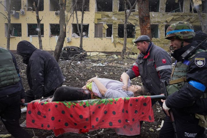 空爆された病院で傷つき、運び出される妊婦
