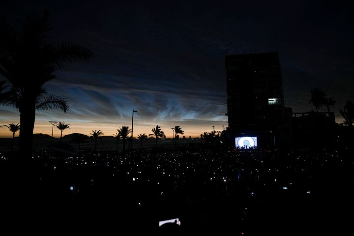 People use their cell phones as the sky darkens during a total solar eclipse in Mazatlan, Mexico, Monday, April 8, 2024. (AP Photo/Fernando Llano)