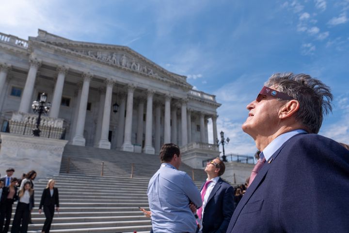 Sen. Joe Manchin, D-W.Va., wears eclipse glasses as he views the moon partially covering the sun during a total solar eclipse, in front of the U.S. Senate on Capitol Hill, Monday, April 8, 2024, in Washington. (AP Photo/Alex Brandon)