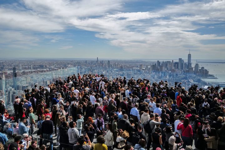 People look toward the sky at the 'Edge at Hudson Yards' observation deck ahead of a solar eclipse across North America, in New York City on April 8, 2024. This year's path of totality is 115 miles (185 kilometers) wide and home to nearly 32 million Americans, with an additional 150 million living less than 200 miles from the strip. The next total solar eclipse that can be seen from a large part of North America won't come around until 2044. (Photo by Charly TRIBALLEAU / AFP) (Photo by CHARLY TRIBALLEAU/AFP via Getty Images)