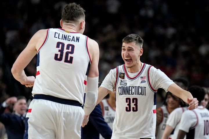 UConn center Donovan Clingan (32) celebrates with guard Apostolos Roumoglou (33) during the second half of the NCAA college Final Four championship basketball game against Purdue, Monday, April 8, 2024, in Glendale, Ariz. (AP Photo/Brynn Anderson)