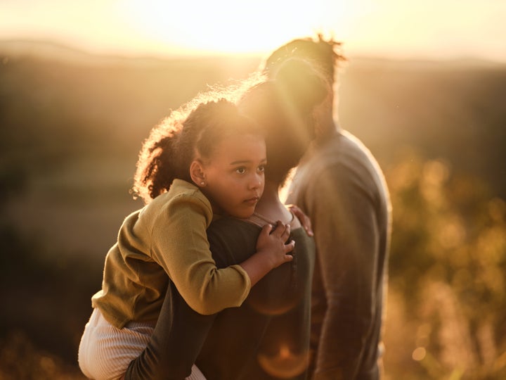 Depressed African American girl spending an autumn day with her parents in nature at sunset. Copy space.