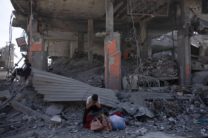 Palestinians sit on the destruction in the wake of an Israeli air and ground offensive in Khan Younis, southern Gaza Strip, on April 8, 2024. Israel says it has withdrawn its last ground troops from the city, ending a four-month operation.