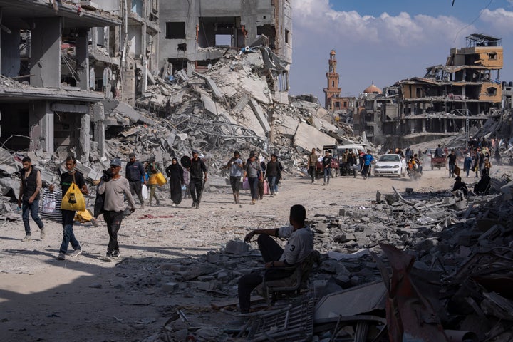 Palestinians walk through the destruction in the wake of an Israeli air and ground offensive in Khan Younis, southern Gaza Strip, on April 8, 2024. Israel says it has withdrawn its last ground troops from the city, ending a four-month operation.
