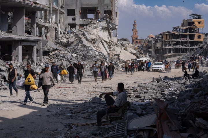 Palestinians walk through the destruction in the wake of an Israeli air and ground offensive in Khan Younis, southern Gaza Strip, on April 8, 2024. Israel says it has withdrawn its last ground troops from the city, ending a four-month operation. 